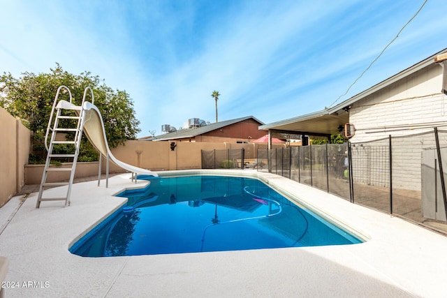 view of swimming pool with a patio area and a water slide