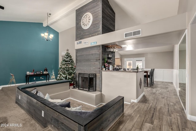 kitchen featuring decorative light fixtures, vaulted ceiling with beams, a fireplace, a notable chandelier, and wood-type flooring