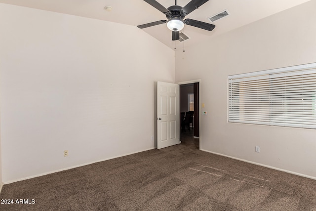 spare room featuring dark colored carpet, ceiling fan, and lofted ceiling