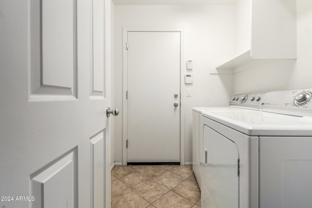 clothes washing area with light tile patterned floors and washer and clothes dryer