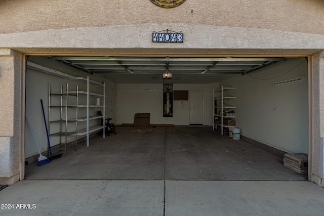 garage with strapped water heater and a garage door opener