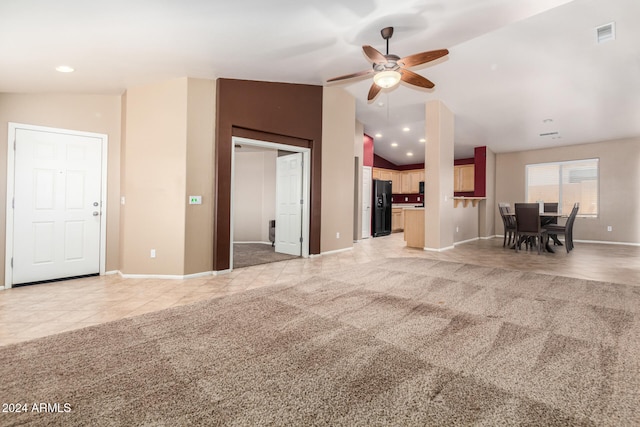 unfurnished living room with ceiling fan, light colored carpet, and lofted ceiling