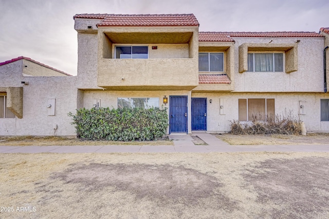 view of front of property featuring a tile roof and stucco siding