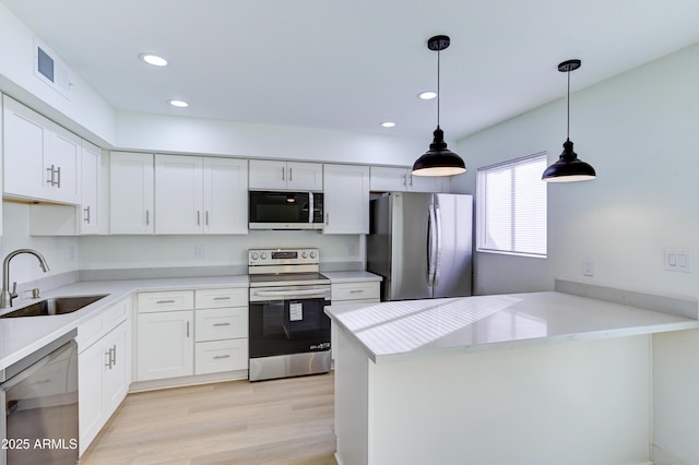 kitchen featuring visible vents, white cabinetry, stainless steel appliances, and a sink