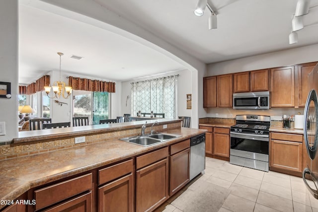 kitchen with brown cabinets, visible vents, stainless steel appliances, and a sink