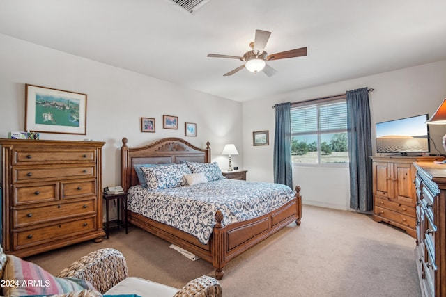 bedroom with light colored carpet, ceiling fan, and visible vents