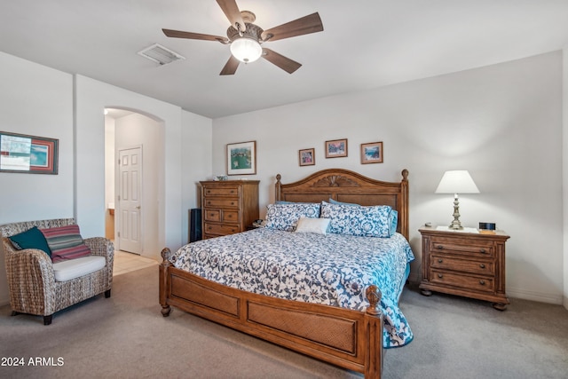 bedroom with arched walkways, ceiling fan, carpet, and visible vents