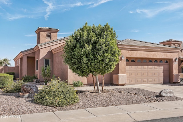 view of front of property with driveway, a garage, and stucco siding