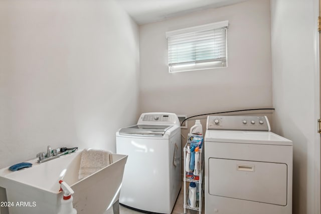 washroom featuring washer and dryer, laundry area, and a sink