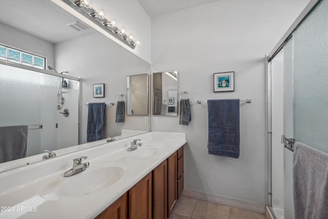 full bathroom featuring tile patterned flooring, a shower stall, and a sink