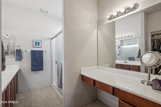 bathroom featuring a stall shower, two vanities, visible vents, and tile patterned floors