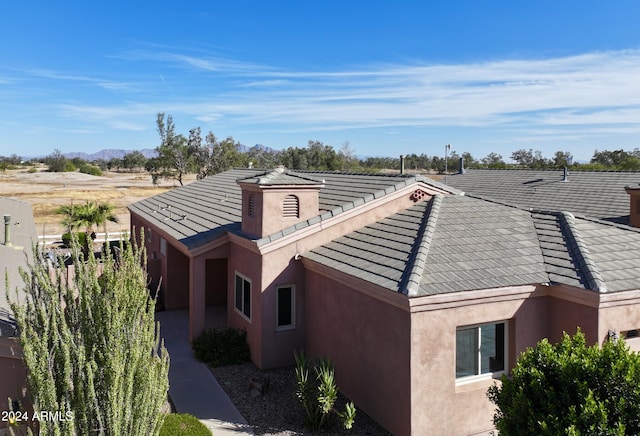 view of side of property with a tiled roof and stucco siding