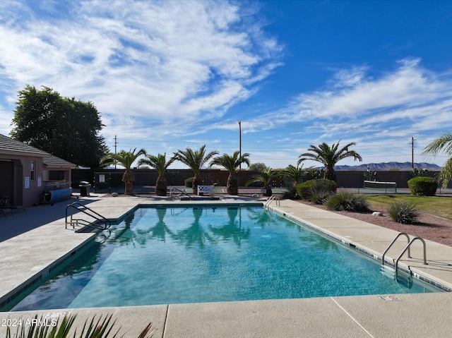 pool with a patio area and fence