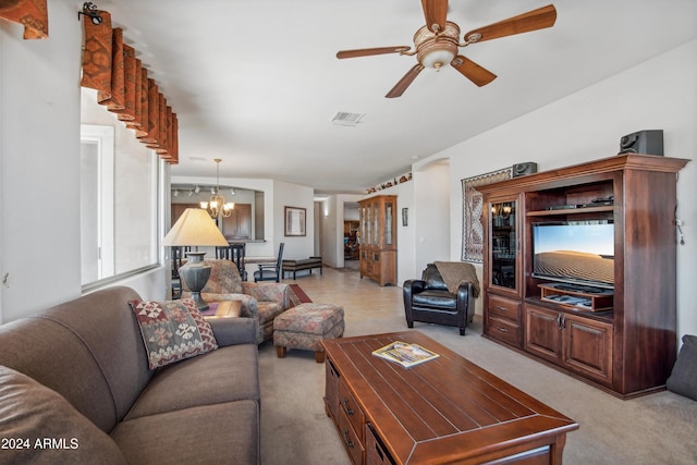 living area with ceiling fan with notable chandelier, visible vents, and light colored carpet