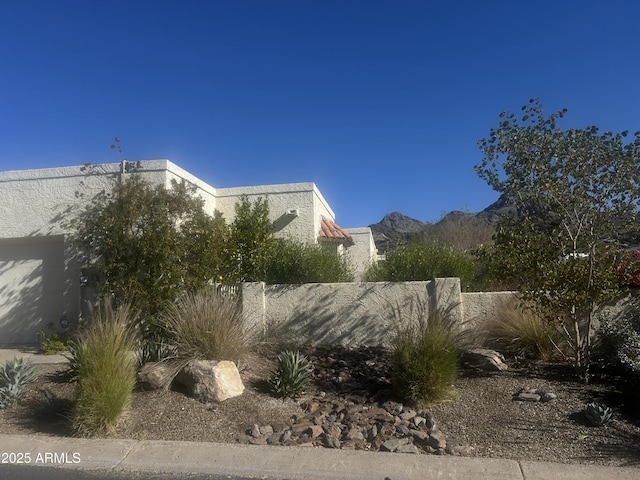 view of side of home featuring fence and a mountain view