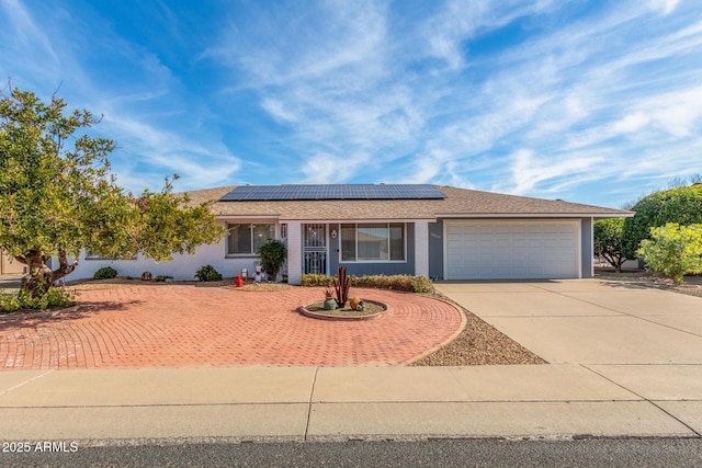 ranch-style house with solar panels and a garage