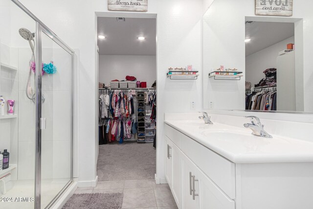 bathroom featuring tile patterned flooring, vanity, and a shower with shower door