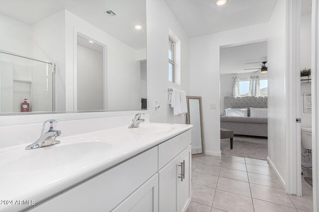 bathroom with vanity, ceiling fan, a shower with door, toilet, and tile patterned floors