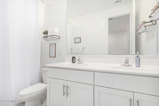 bathroom featuring walk in shower, vanity, and toilet