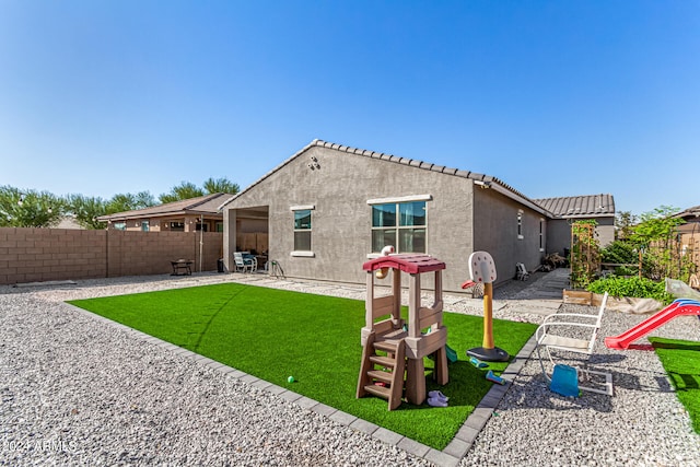 back of property featuring a lawn and a patio