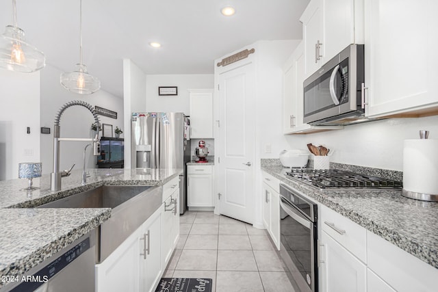 kitchen featuring decorative light fixtures, stainless steel appliances, sink, and white cabinetry