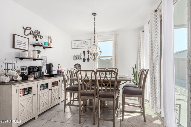 tiled dining room featuring an inviting chandelier