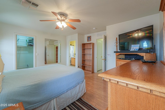 bedroom with light wood-style flooring, a ceiling fan, and visible vents