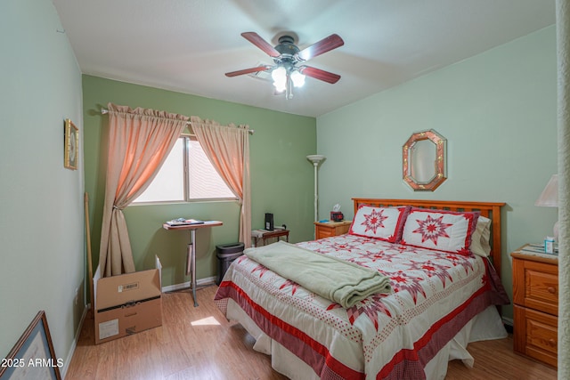 bedroom featuring baseboards, wood finished floors, and a ceiling fan