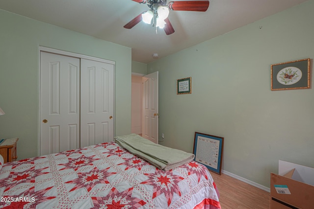 bedroom with a closet, baseboards, light wood-style floors, and ceiling fan