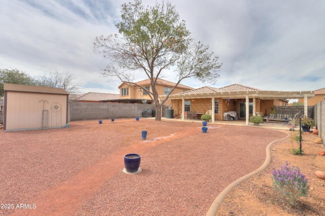 back of house with a patio, a shed, a fenced backyard, stucco siding, and an outdoor structure