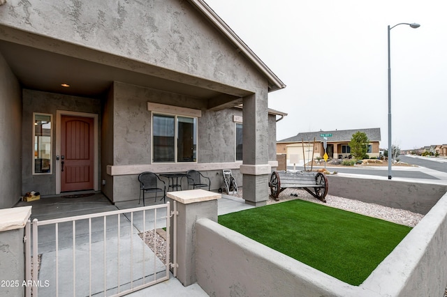 doorway to property with a porch and stucco siding