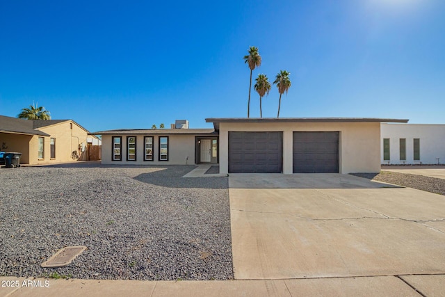 view of front of property with a garage, driveway, and stucco siding