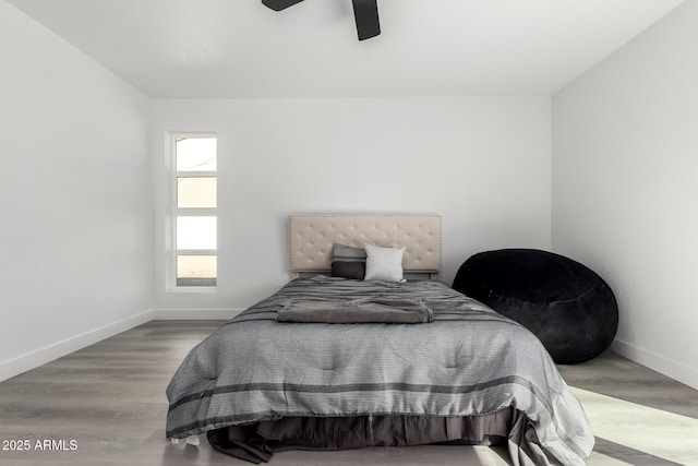 bedroom with wood finished floors, a ceiling fan, and baseboards