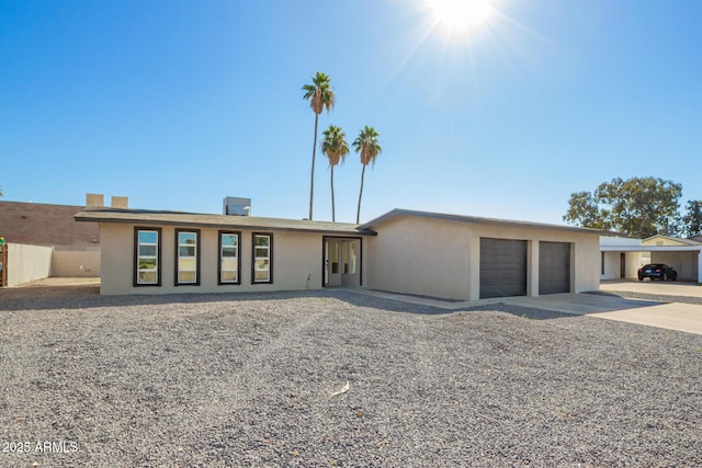 view of front of house with concrete driveway, an attached garage, and stucco siding