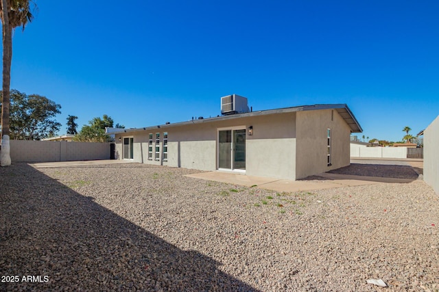 back of property featuring central AC unit, a patio area, a fenced backyard, and stucco siding