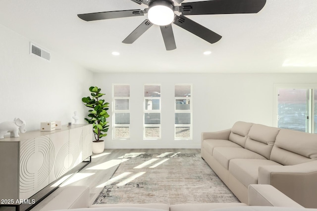 living room featuring light wood-style floors, visible vents, and recessed lighting