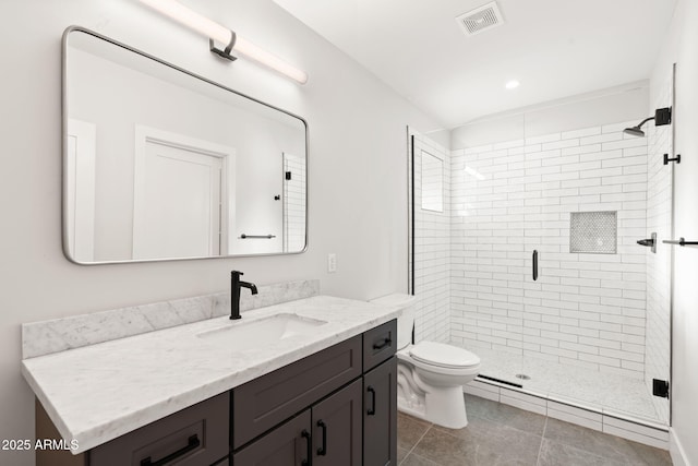 bathroom featuring vanity, tile patterned flooring, a shower with shower door, and toilet