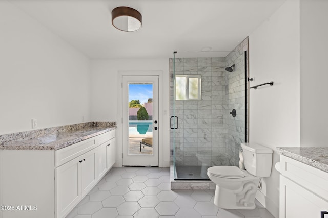 bathroom with tile patterned flooring, vanity, toilet, and walk in shower