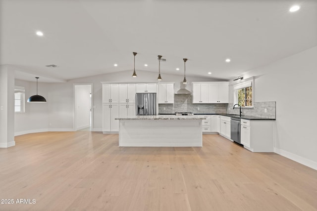 kitchen with stainless steel appliances, sink, hanging light fixtures, and white cabinets