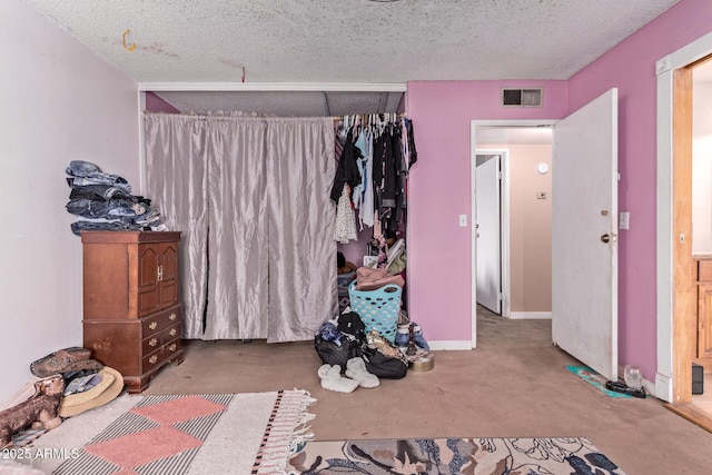 unfurnished bedroom with concrete flooring and a textured ceiling