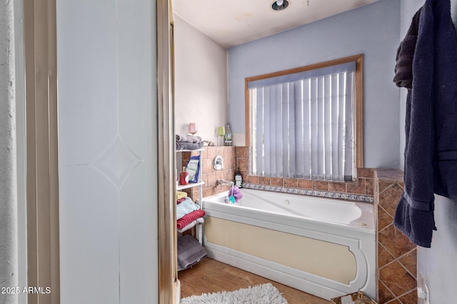 full bath featuring a garden tub and wood finished floors