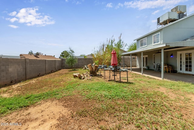 fenced backyard with a patio area and french doors