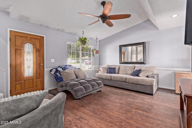 living area with a textured ceiling, lofted ceiling, a ceiling fan, a wainscoted wall, and wood finished floors