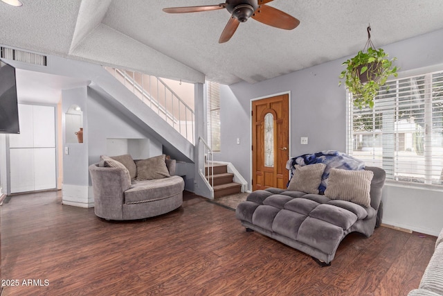 living room with stairs, a textured ceiling, ceiling fan, wood finished floors, and vaulted ceiling