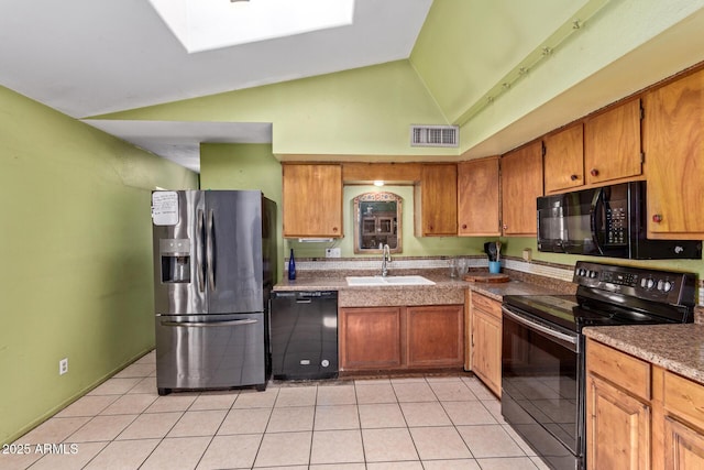 kitchen featuring black appliances, a sink, light tile patterned floors, brown cabinetry, and high vaulted ceiling