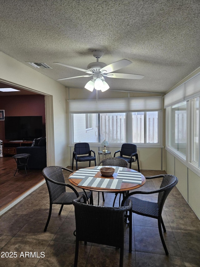 dining area featuring a textured ceiling, visible vents, ceiling fan, and plenty of natural light