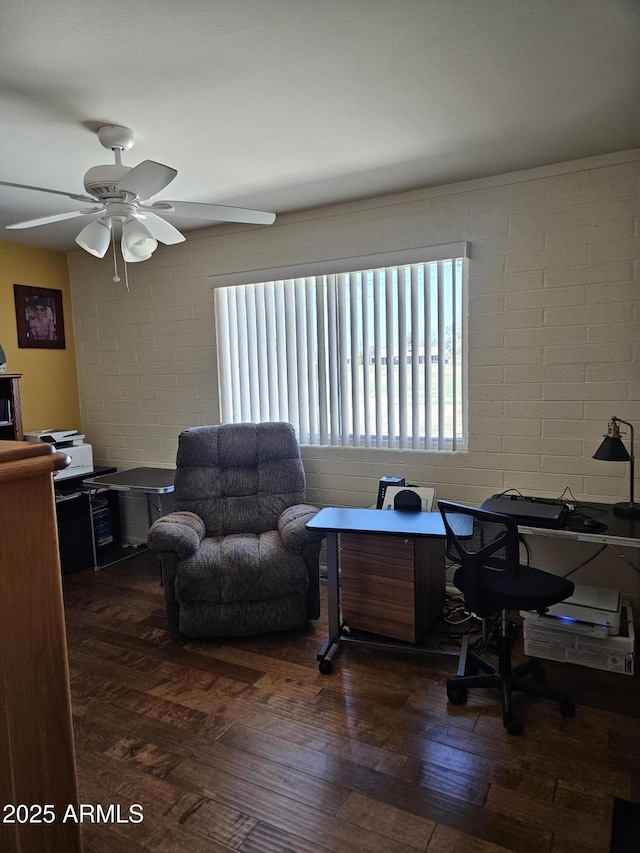 office area with concrete block wall, ceiling fan, and wood finished floors