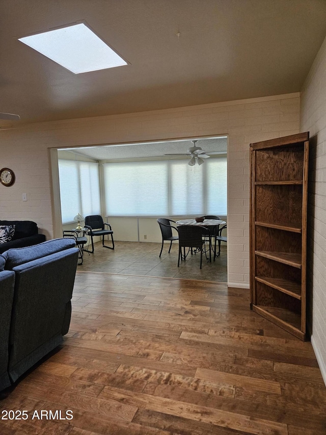 interior space featuring plenty of natural light, hardwood / wood-style flooring, a ceiling fan, and a skylight
