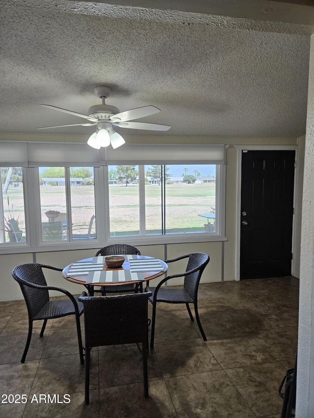 dining room with a textured ceiling and ceiling fan