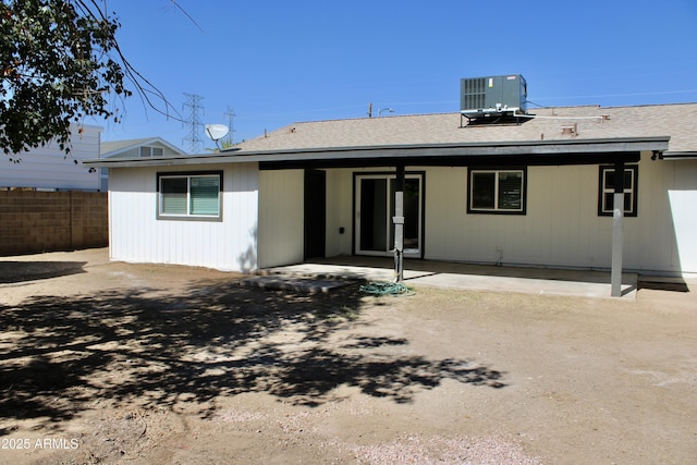 rear view of property with a shingled roof, fence, cooling unit, and a patio